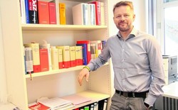 Richter am Amtsgericht Dr. Marcus Lemke in seinem Büro neben Gesetzesbüchern