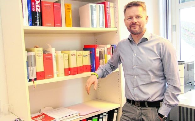 Richter am Amtsgericht Dr. Marcus Lemke in seinem Büro neben Gesetzesbüchern